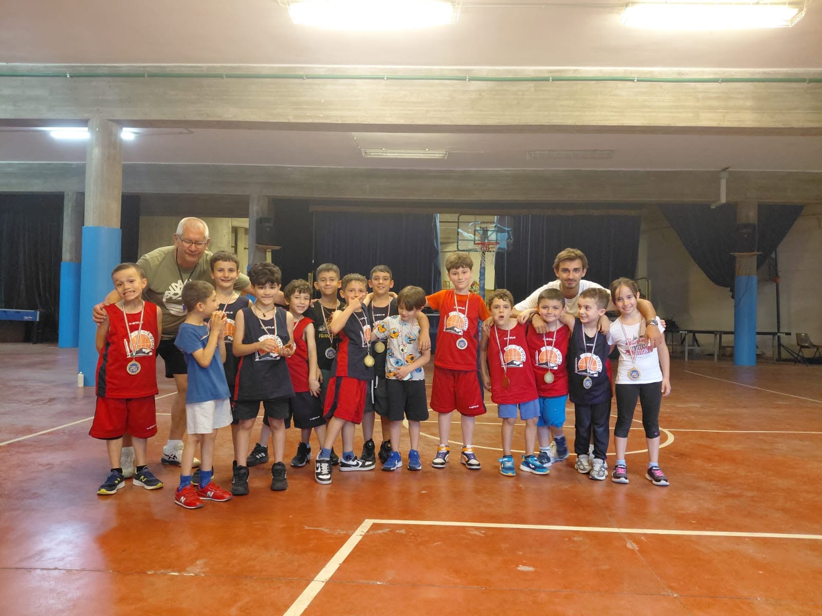 Gruppo di bambini e istruttori al termine di un'attività di minibasket